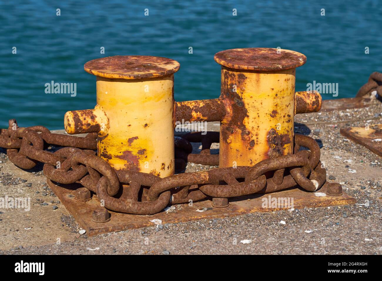Vue latérale d'UN double bollard d'amarrage de bitt avec une chaîne lourde autour d'elle. Banque D'Images