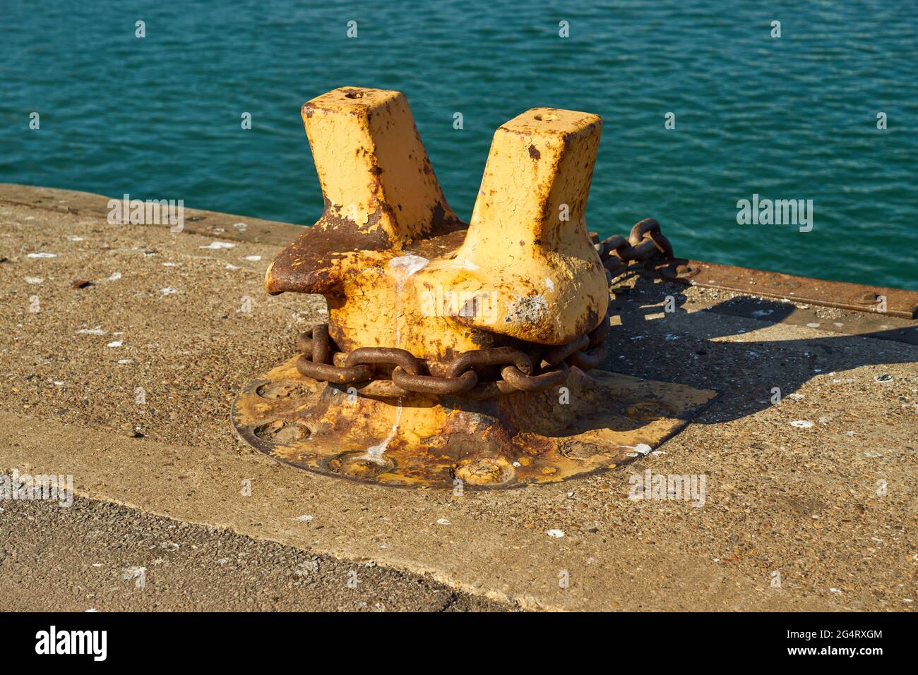 Un bollard d'amarrage à double corne avec une chaîne lourde autour d'elle Banque D'Images