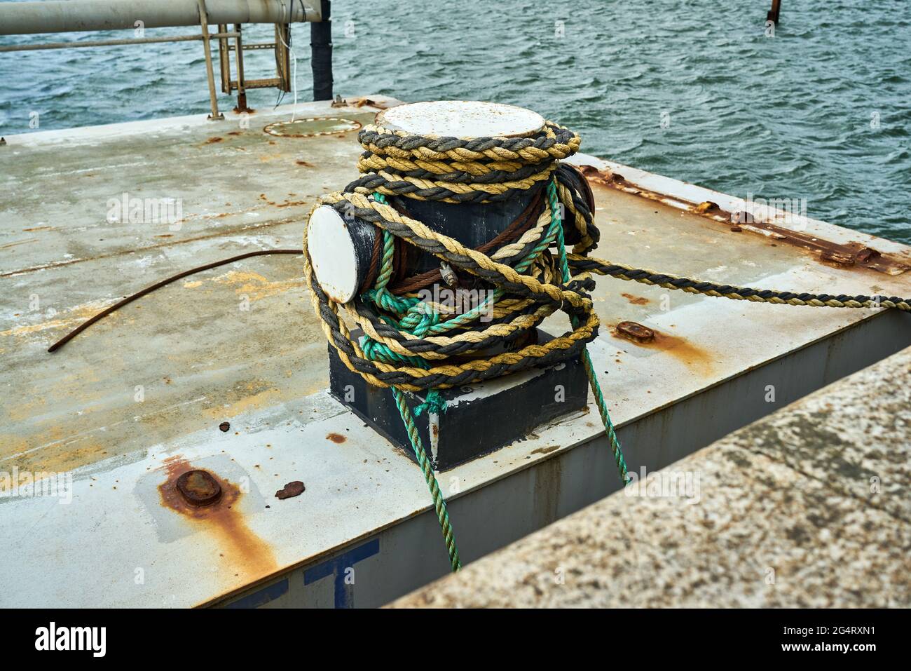 Vue latérale d'un bollard à croûtes avec corde d'amarrage pour fixer un bateau Banque D'Images