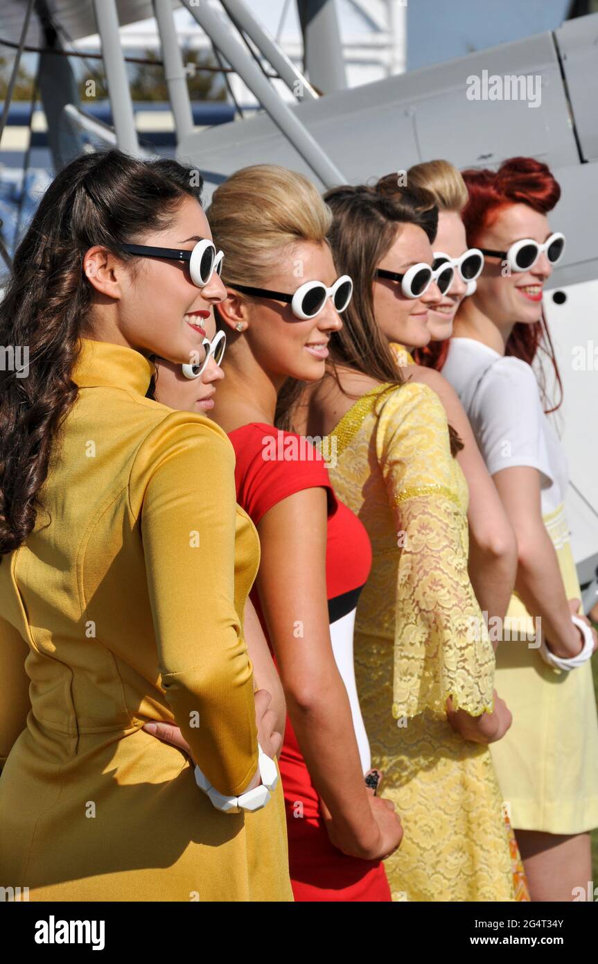 Les filles posant dans le style années soixante robe d'époque au Goodwood Revival 2011, Royaume-Uni. Grandes lunettes de soleil. Travaux temporaires pour l'événement. Jeunes femmes modèles Banque D'Images