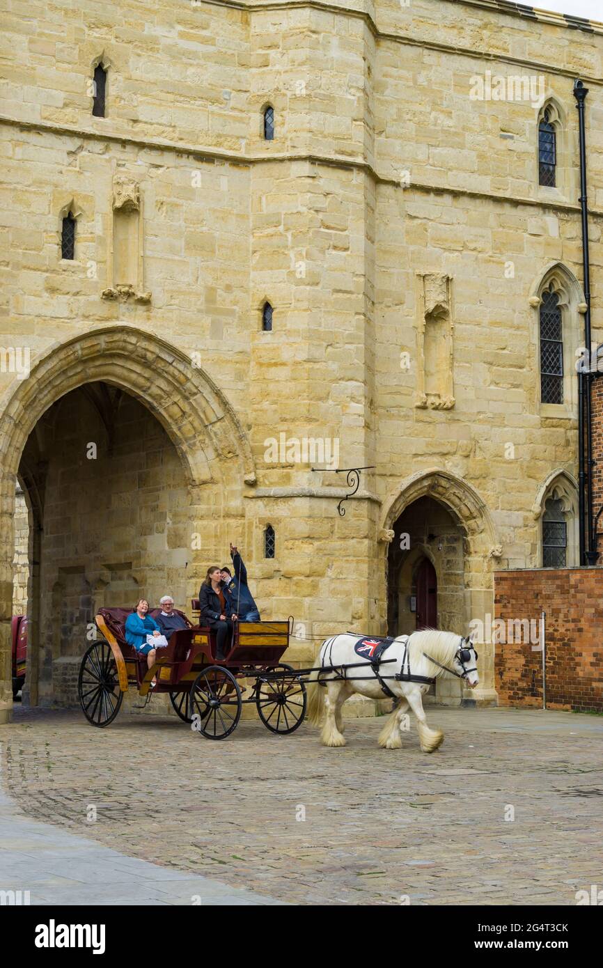 Un chariot à quatre roues tiré par des chevaux et des passagers en voyage autour du quartier de la cathédrale Lincoln City 2021 Banque D'Images