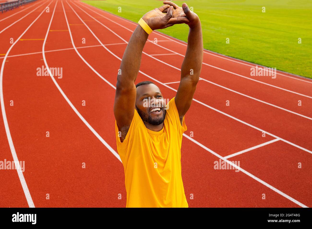 Joyeux jeune africain américain gars se réchauffer, s'étirant les mains, faisant l'exercice d'étirement de la main. Athlète de coureur de sexe masculin travaillant en plein air au Banque D'Images