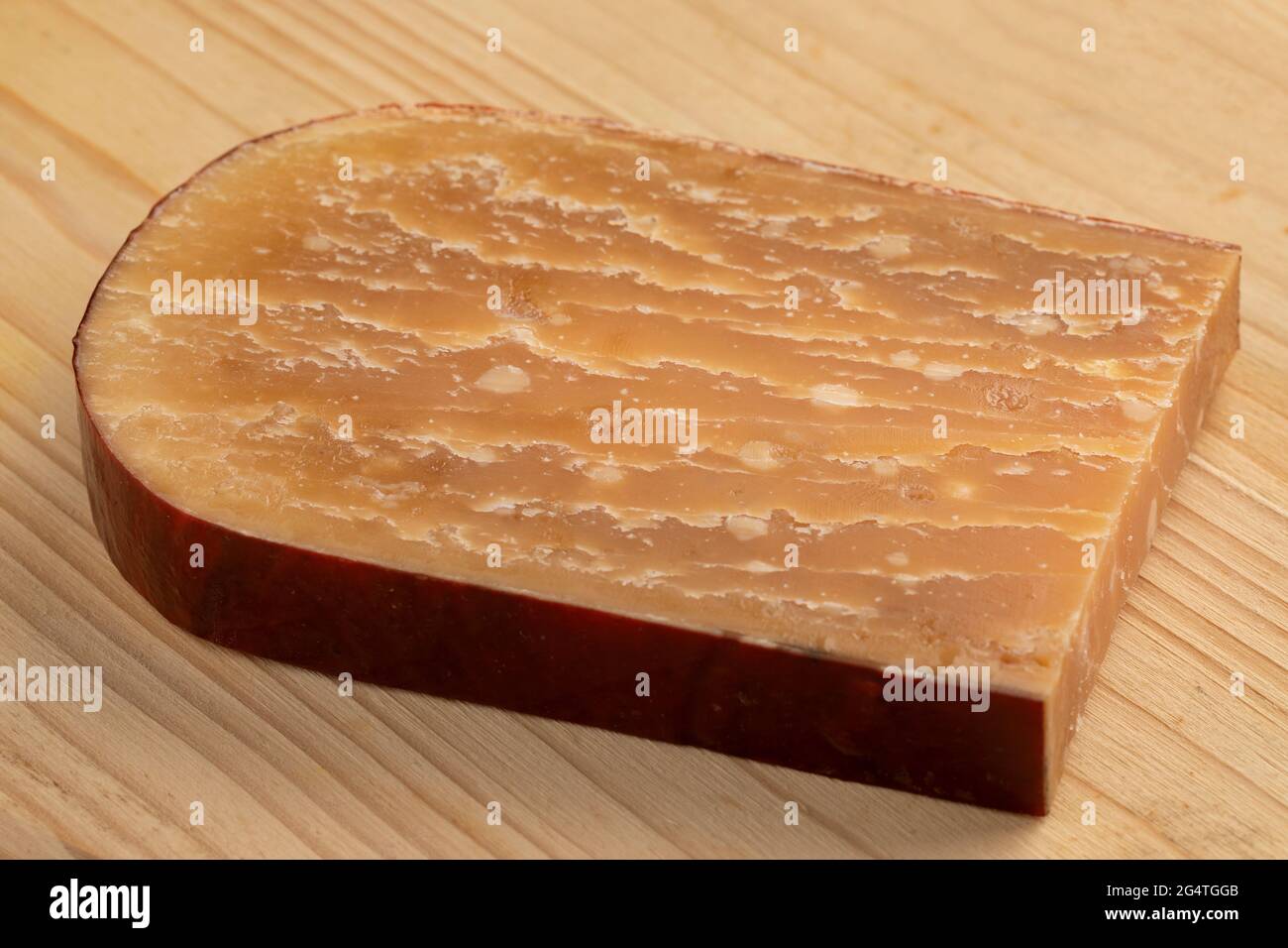 Tranche de vieux fromage de brebis hollandais mûr sur une planche à découper Banque D'Images