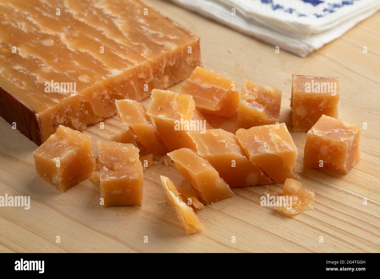 Cubes de vieux fromage de brebis hollandais mûr sur une planche à découper Banque D'Images