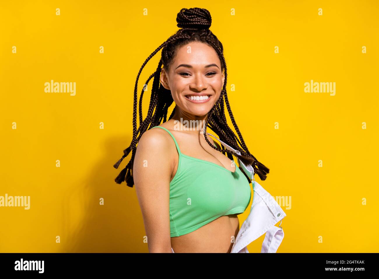 Photo de charmante belle afro américaine jeune femme sourire cheveux de mouche isolés sur fond jaune Banque D'Images
