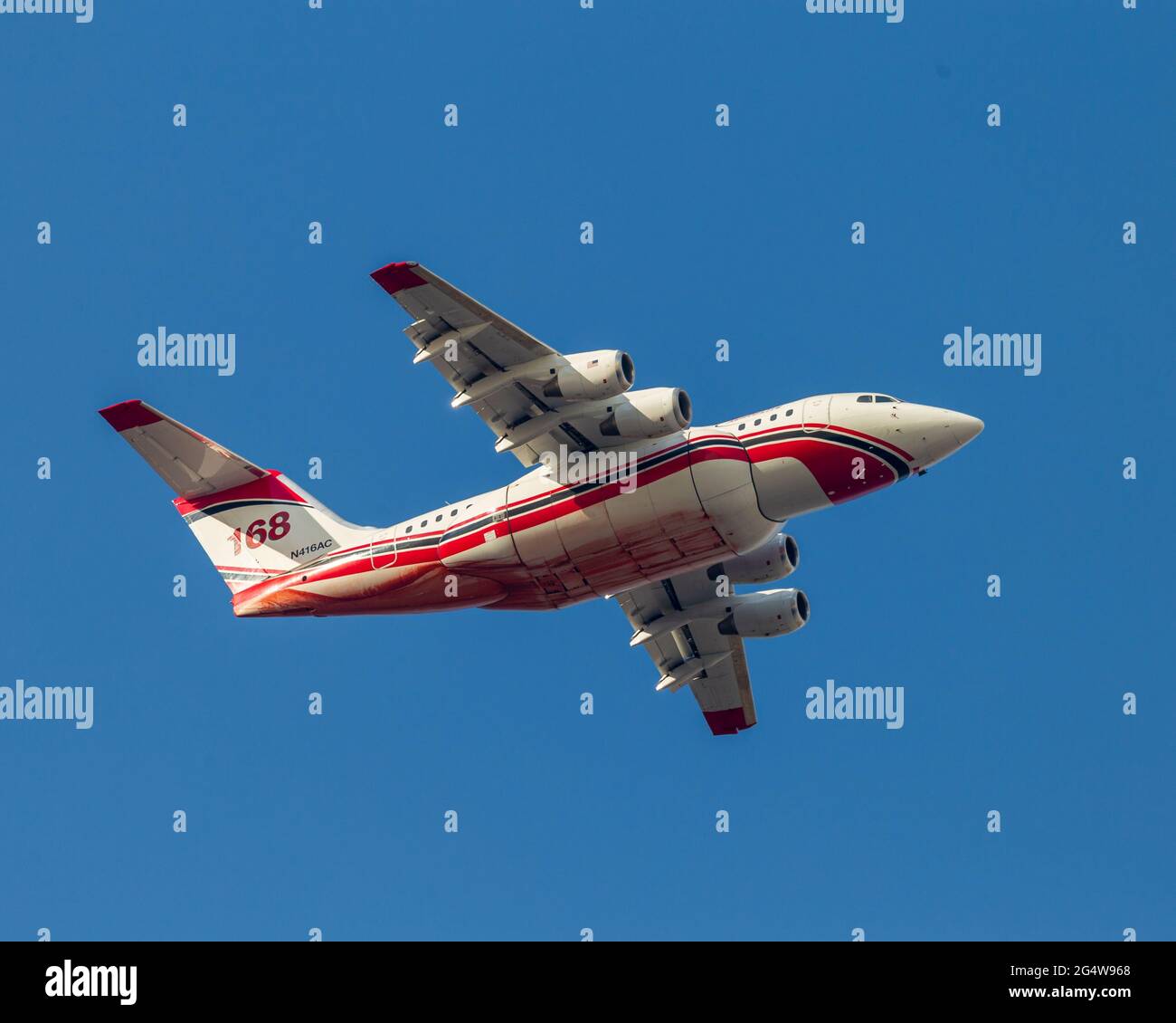 Avro RJ-85 repassant à la base après avoir laissé tomber le produit ignifuge sur le feu de forêt du Canyon, à gauche. Le produit ignifuge est visible le long du ventre de l'avion et de la fusela Banque D'Images