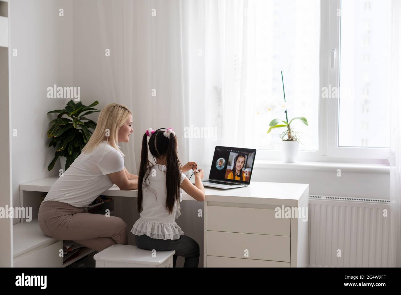 Leçon privée. Une jeune femme attentionnée enseignant aide petite fille élève à étudier le langage mathématique corriger les erreurs expliquer le matériel d'apprentissage Banque D'Images