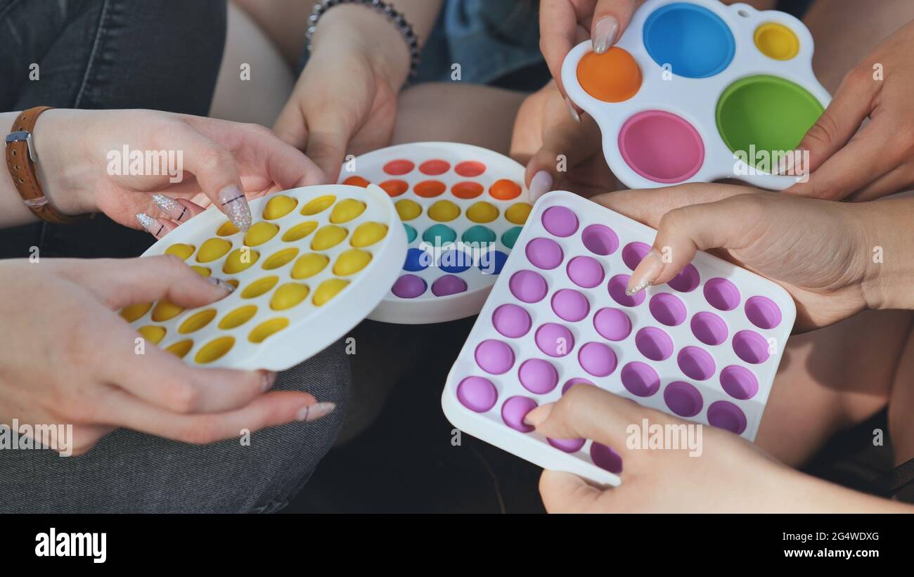 Les filles jouent avec des jouets simples de détente et de la pop. Banque D'Images