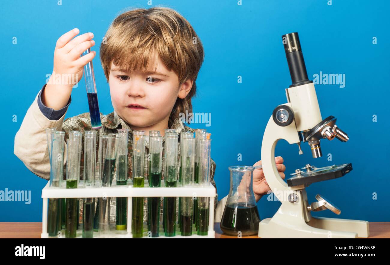 Garçon scientifique en laboratoire. Mignon enfant faisant l'expérience de la science. Petit enfant avec tubes à essai et microscope. Éducation. Banque D'Images