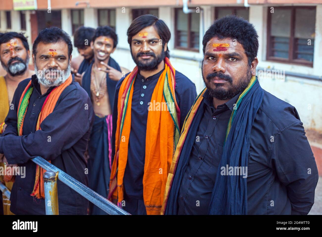 Groupe de dévotés hindous Ayappa portant des vêtements noirs et des foulards orange posent pour la photo, Temple Sri Krishna, Udupi, Karnataka, Inde Banque D'Images