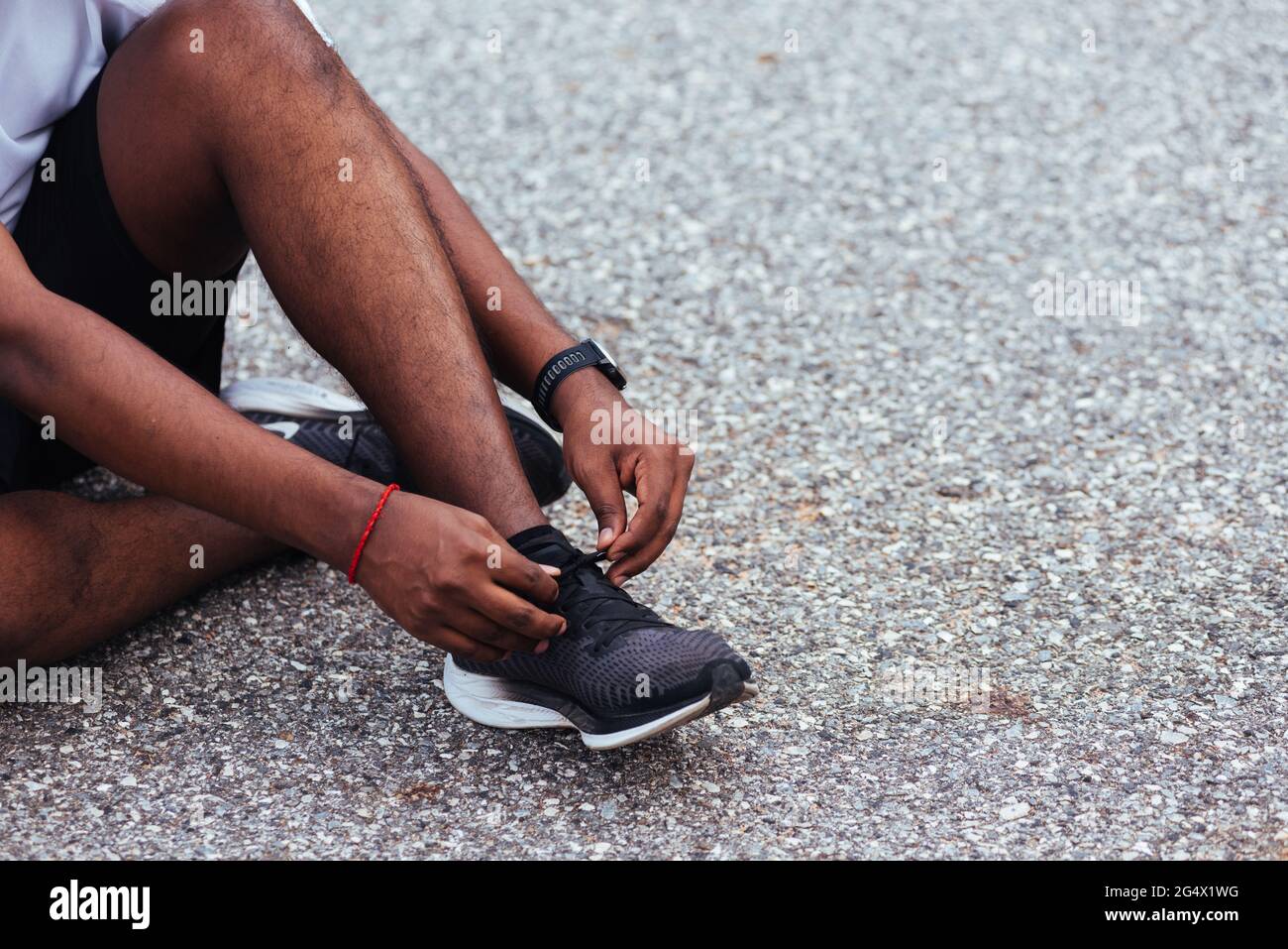 Gros plan asiatique coureur sportif noir homme assis chaussures de course à  pied essayer des chaussures de course à pied se préparer pour le jogging et  courir dans la rue extérieure, exercice