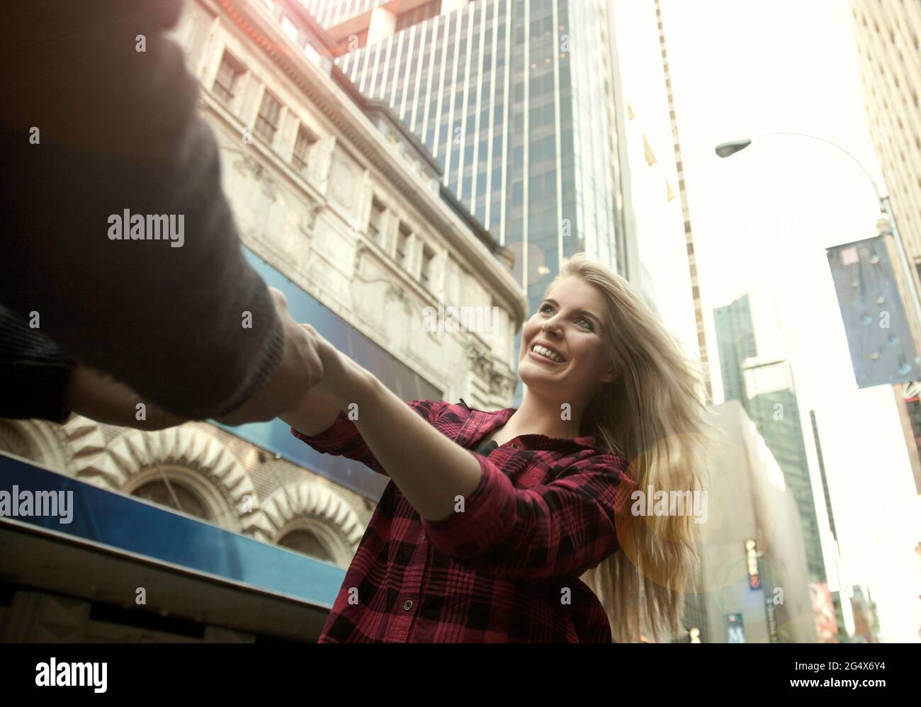 Bonne femme tenant les mains de l'homme en ville Banque D'Images