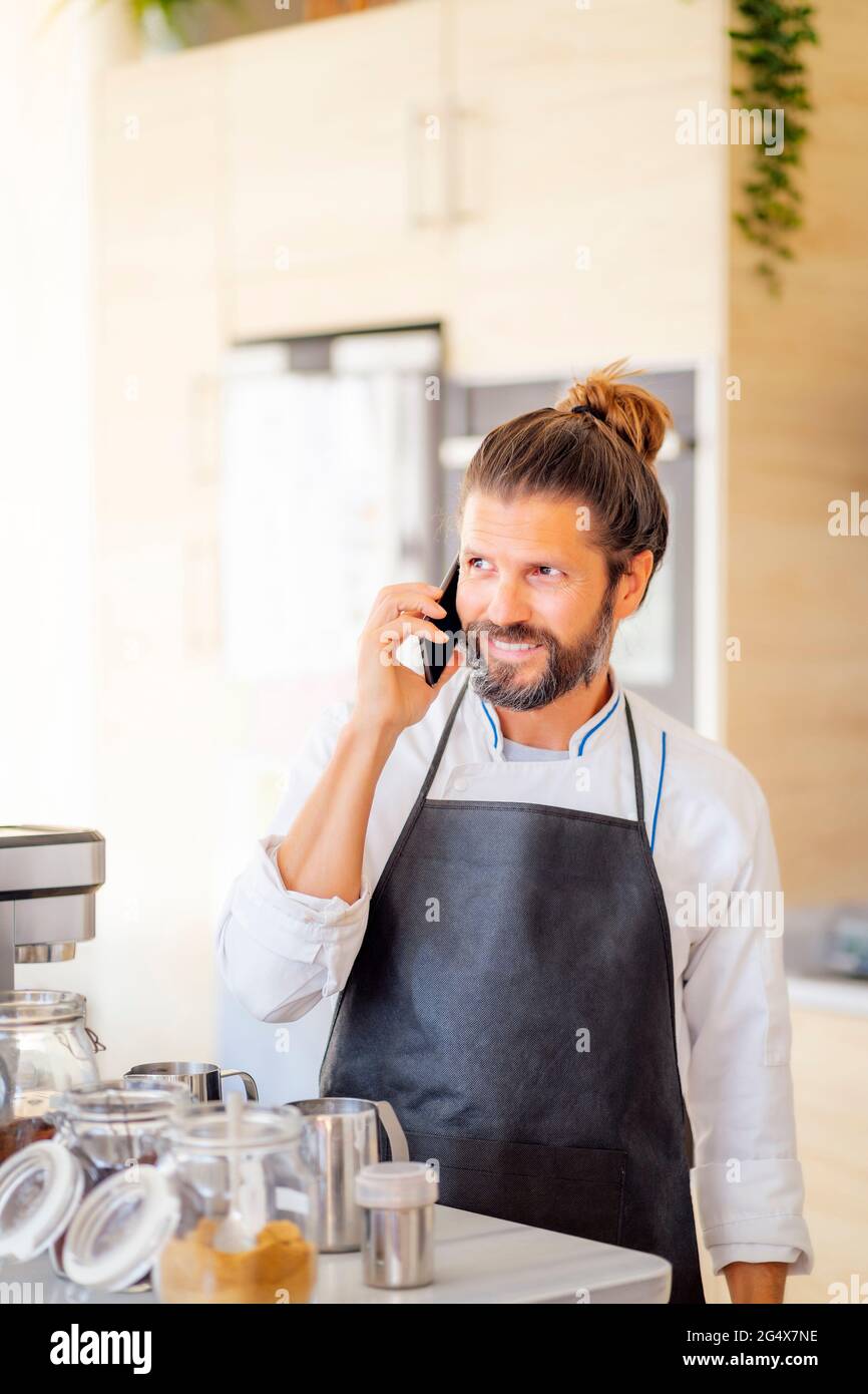 Chef masculin parlant sur téléphone portable dans le restaurant Banque D'Images