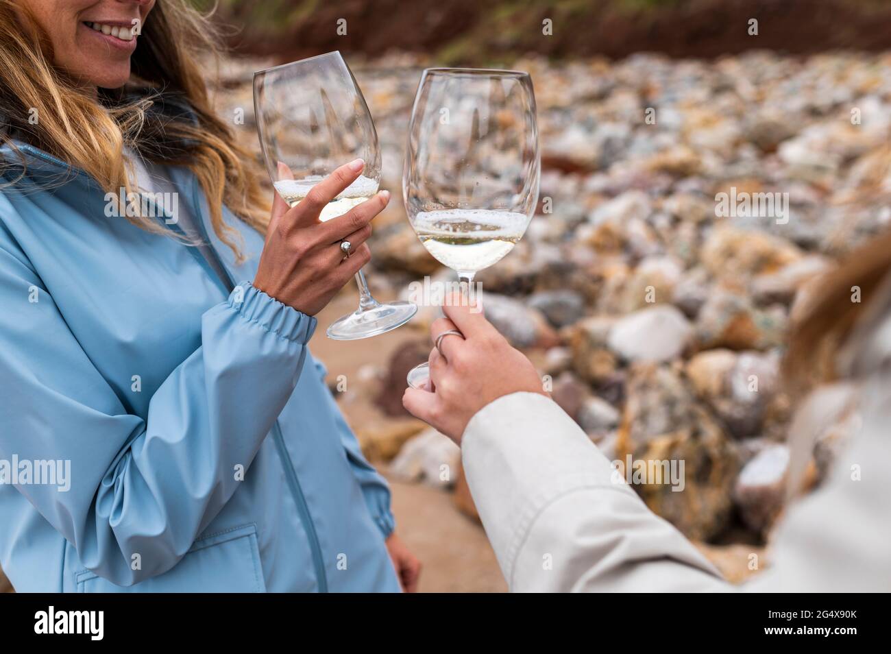 Des amies qui toaster des lunettes de vin à la plage Banque D'Images