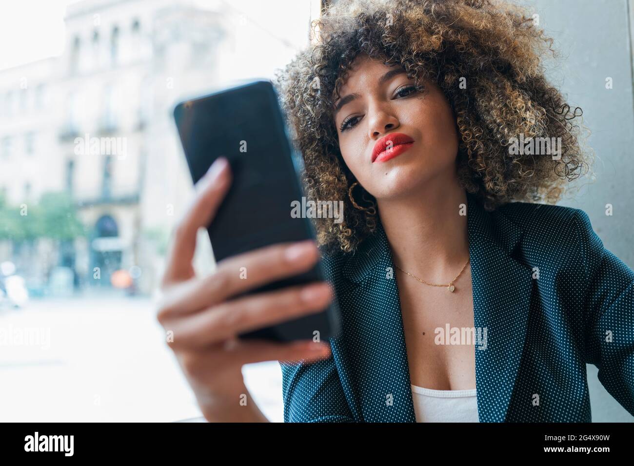 Belle femme d'affaires messagerie texte par téléphone intelligent dans le café Banque D'Images