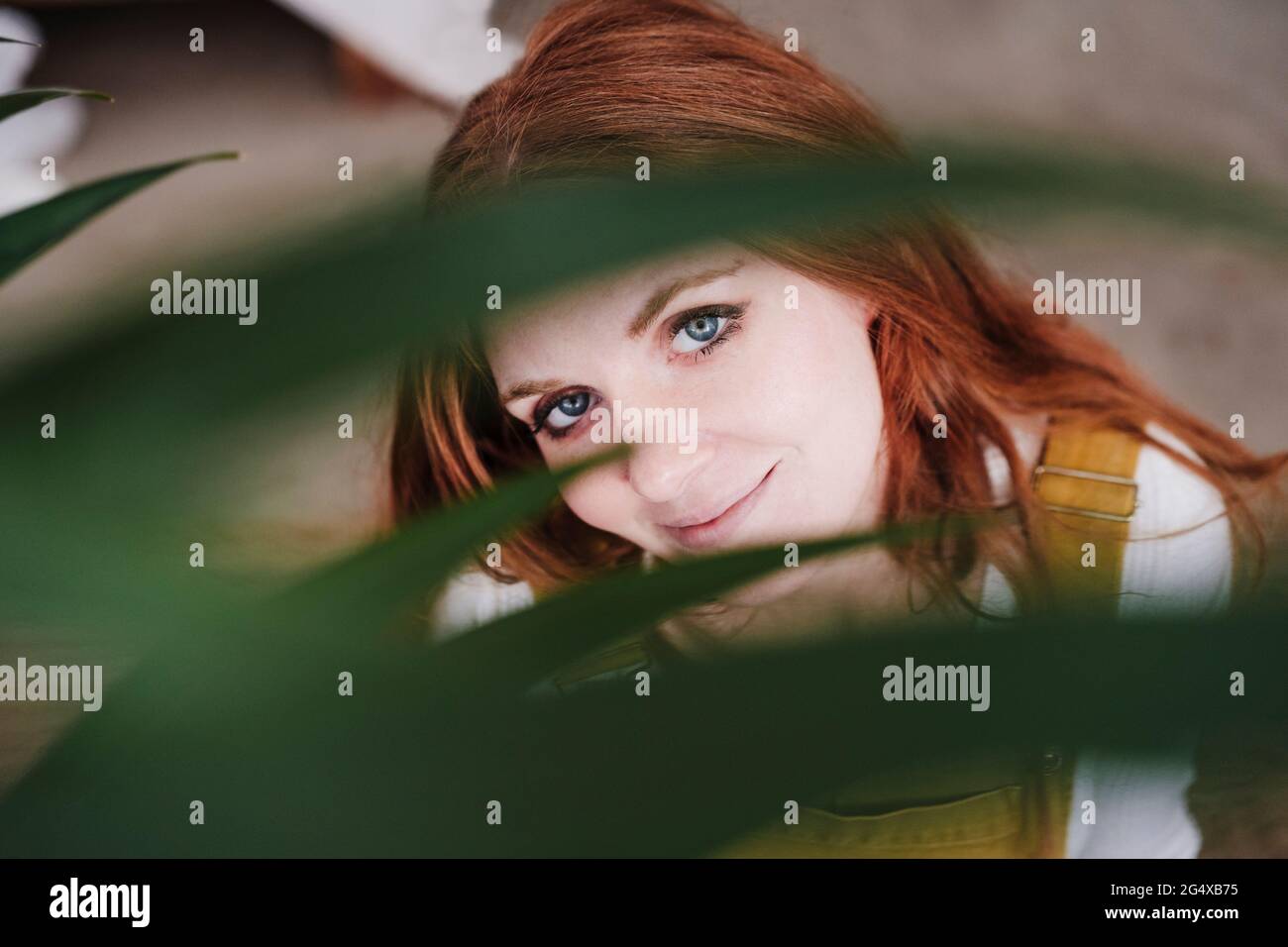 Belle femme vue à travers les feuilles Banque D'Images