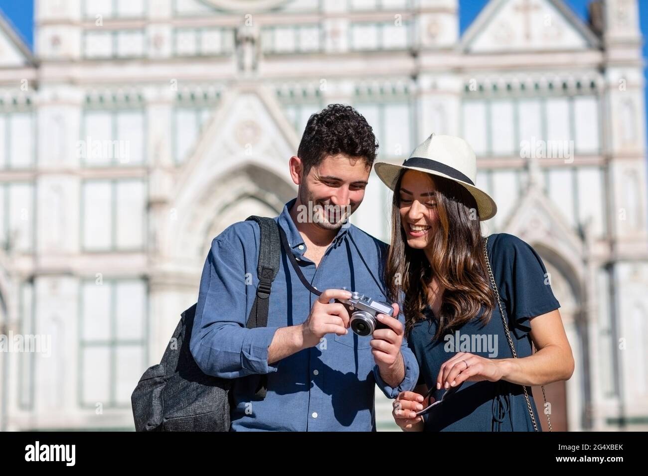 Souriant touristes vérifiant la caméra avec la basilique de Santa Croce en arrière-plan à Florence, Italie Banque D'Images