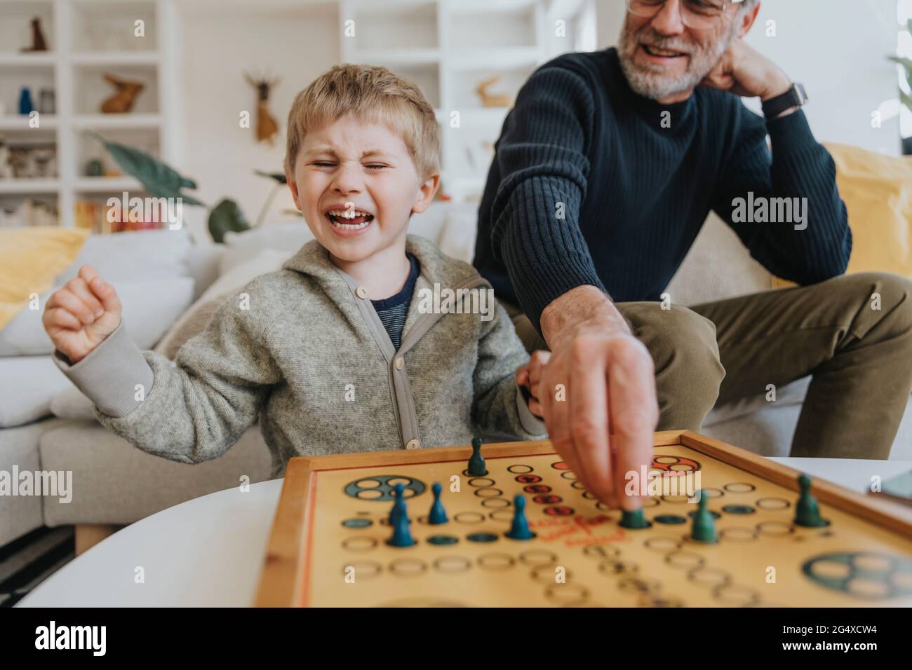 Un fils joyeux jouant au ludo avec son père à la maison Banque D'Images