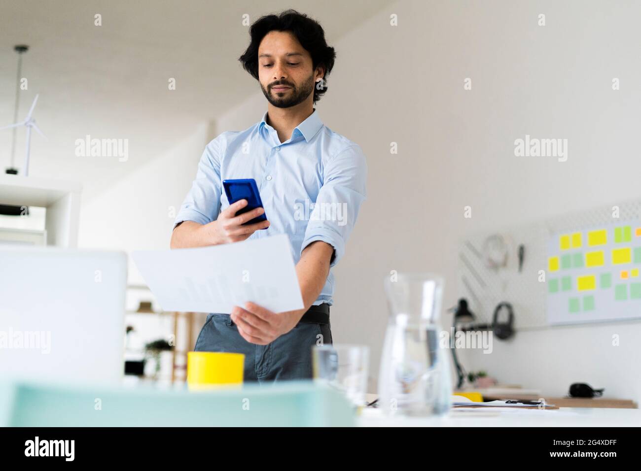 Homme d'affaires prenant des photos de document par smartphone au bureau Banque D'Images