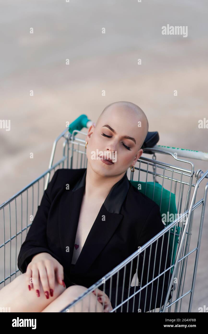 Femme bald transgenre dormant dans un panier Banque D'Images