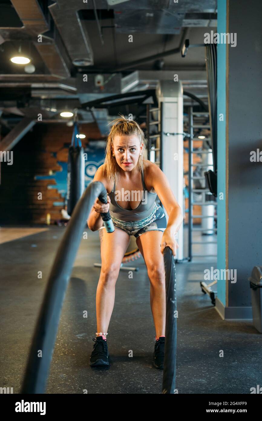 Athlète féminine faisant de l'exercice de corde à la salle de gym Banque D'Images