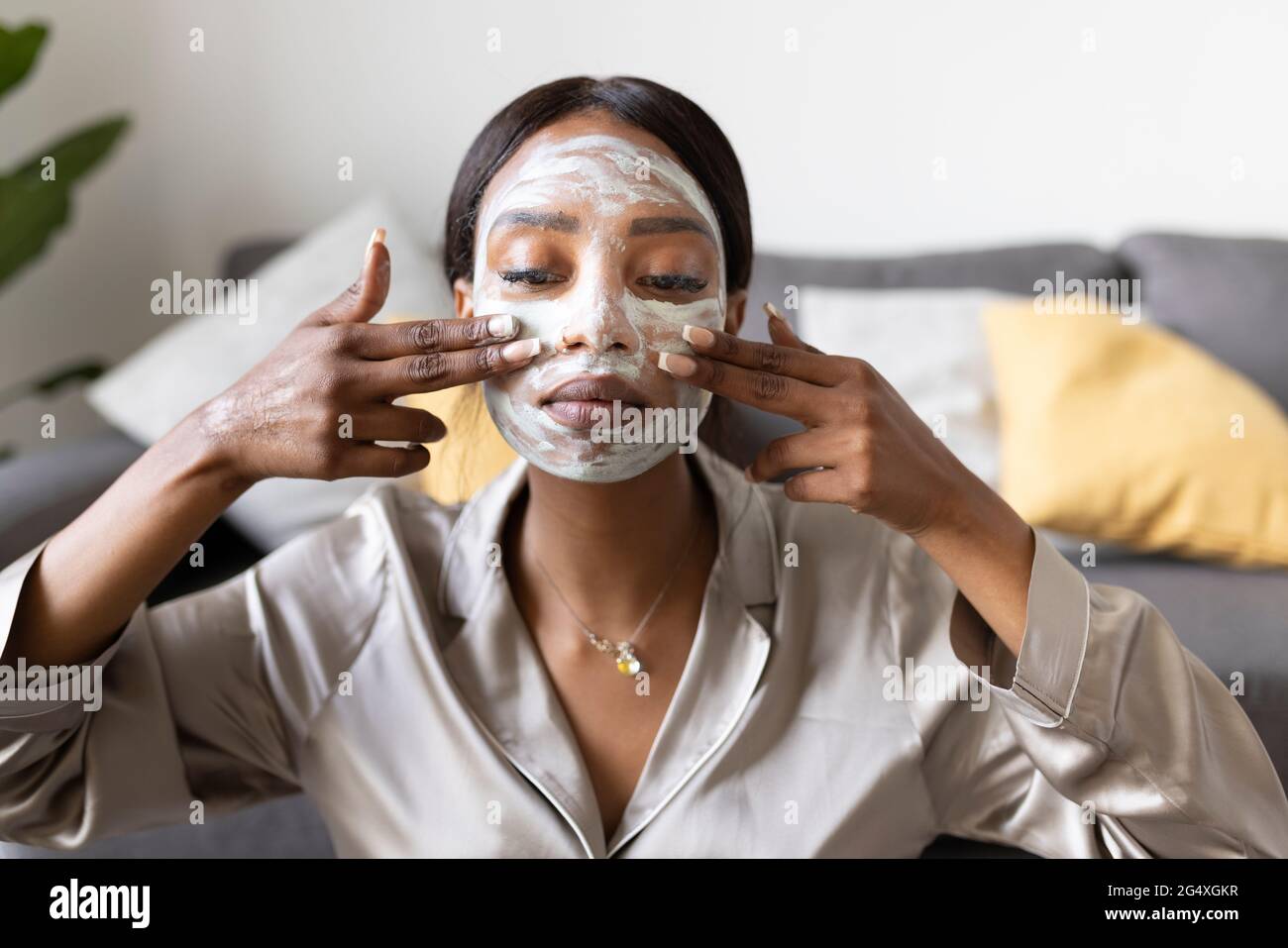 Young woman applying facial mask Banque D'Images