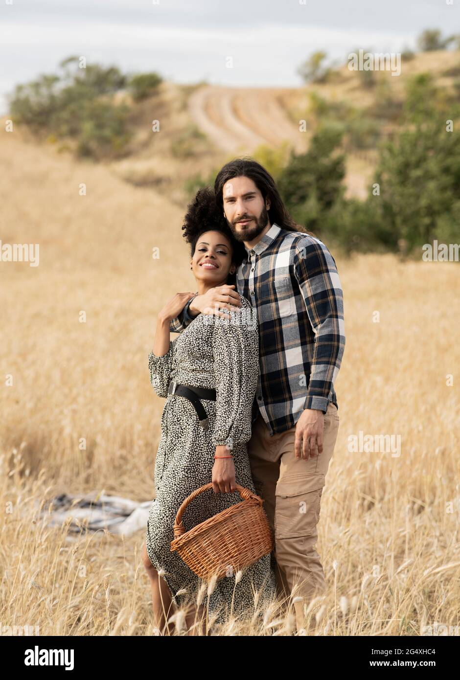 Homme avec le bras autour de la femme debout sur le terrain Banque D'Images