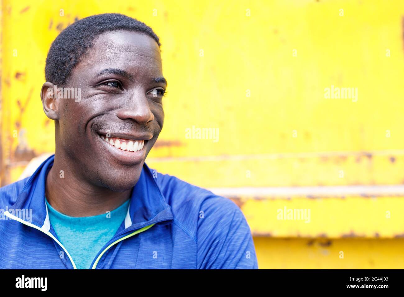 Homme souriant devant le fer ondulé Banque D'Images