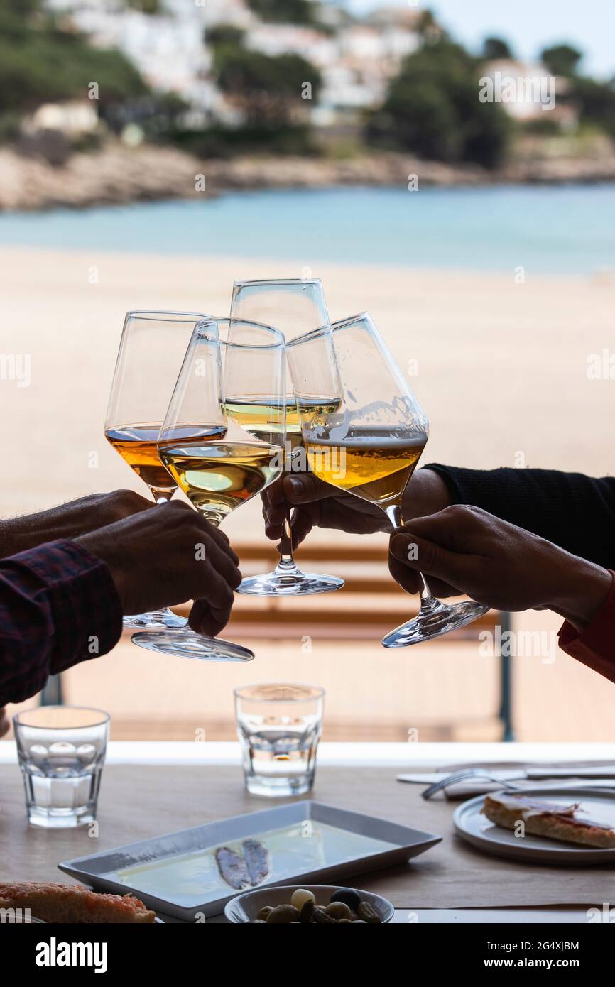 Des amis qui toastent avec des verres à vin au restaurant de la plage Banque D'Images