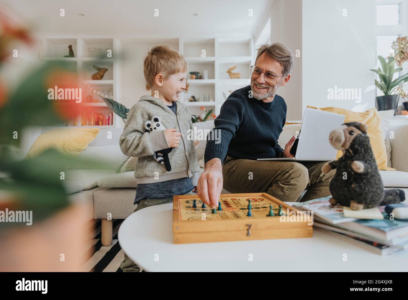 Joyeux père jouant au ludo avec son fils à la maison Banque D'Images