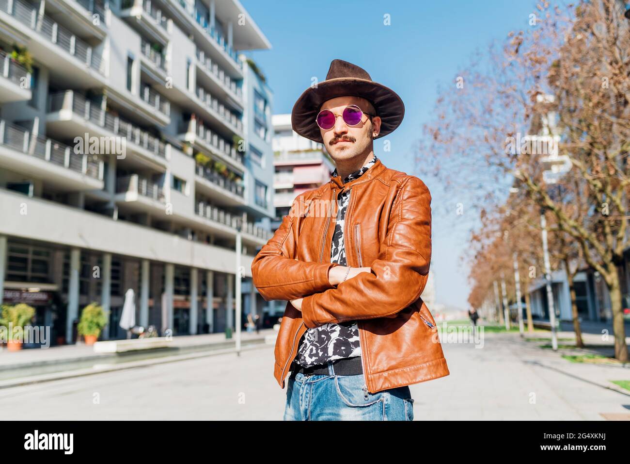 Homme portant un chapeau en regardant loin tout en se tenant sur la marche pendant la journée ensoleillée Banque D'Images