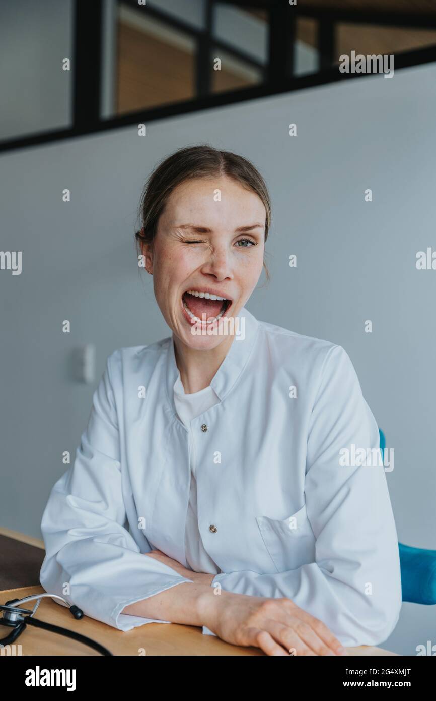 Une employée de soins de santé avec la bouche ouverte faisant face au bureau Banque D'Images