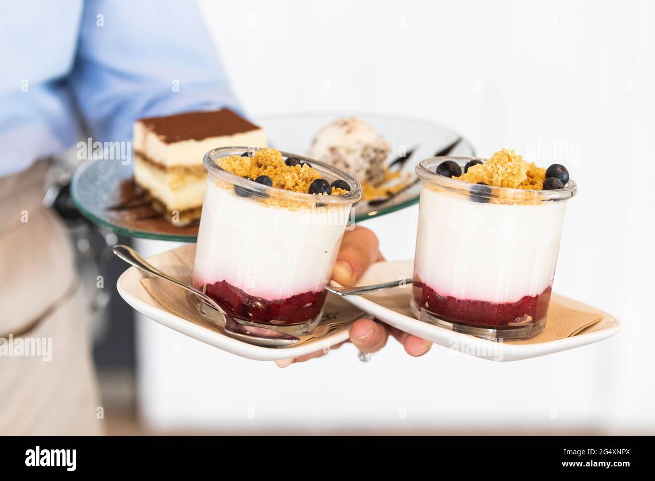 Un serveur sert des mets sucrés au restaurant Banque D'Images