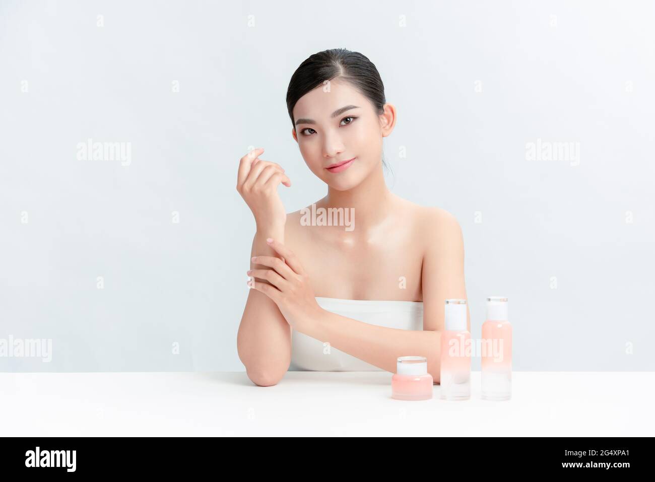 une femme avec des bouteilles cosmétiques dans la table Banque D'Images