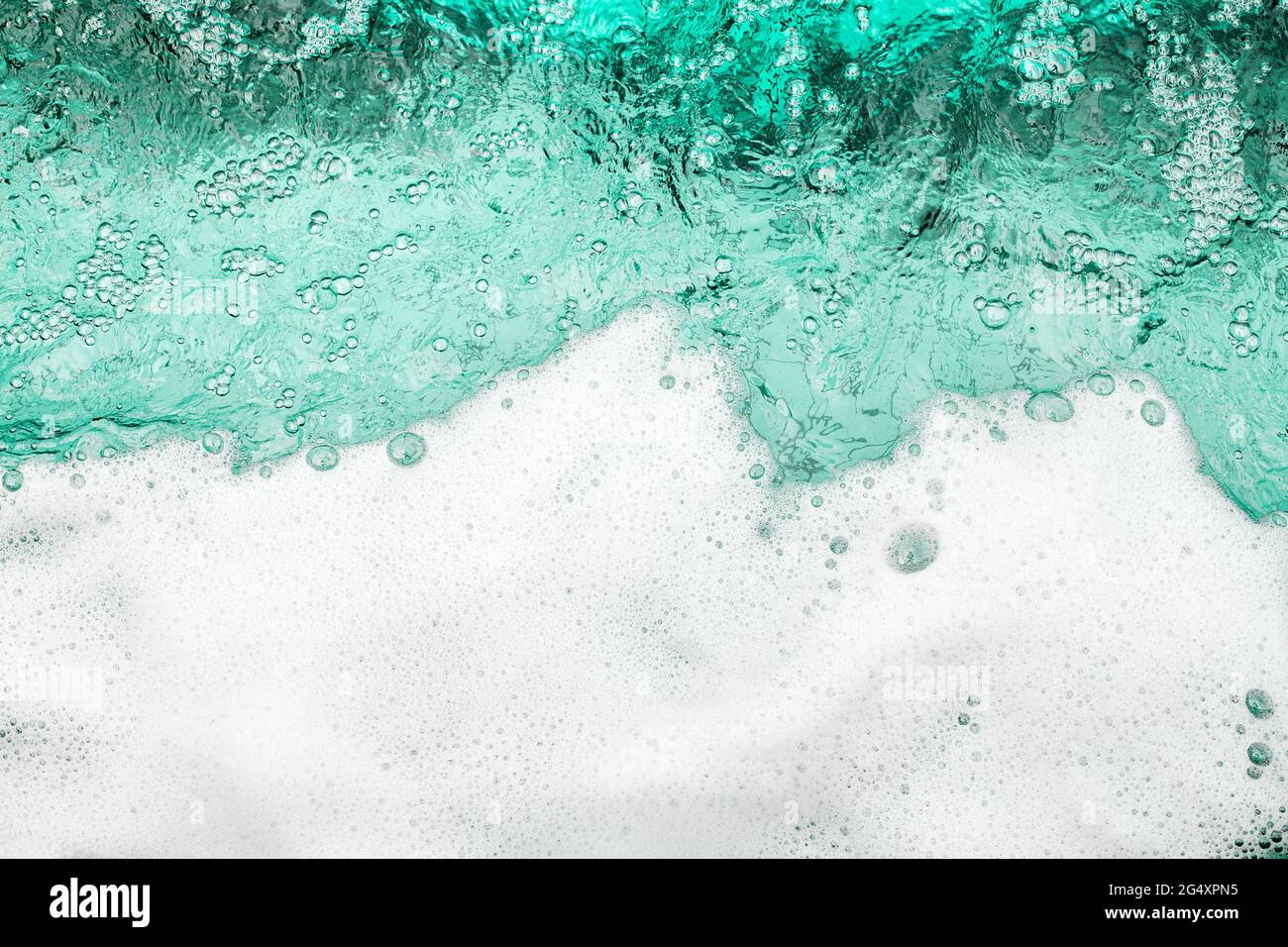 Mousse blanche fond d'eau bleu clair, bordure d'onde de mousse d'océan, texture des bulles de mousse, toile de fond moulante, motif de suds de savon, surface savonneuse Banque D'Images