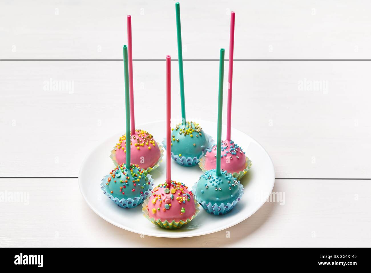 Les gâteaux se sucent en rose et en bleu avec des saupoudres colorées Banque D'Images