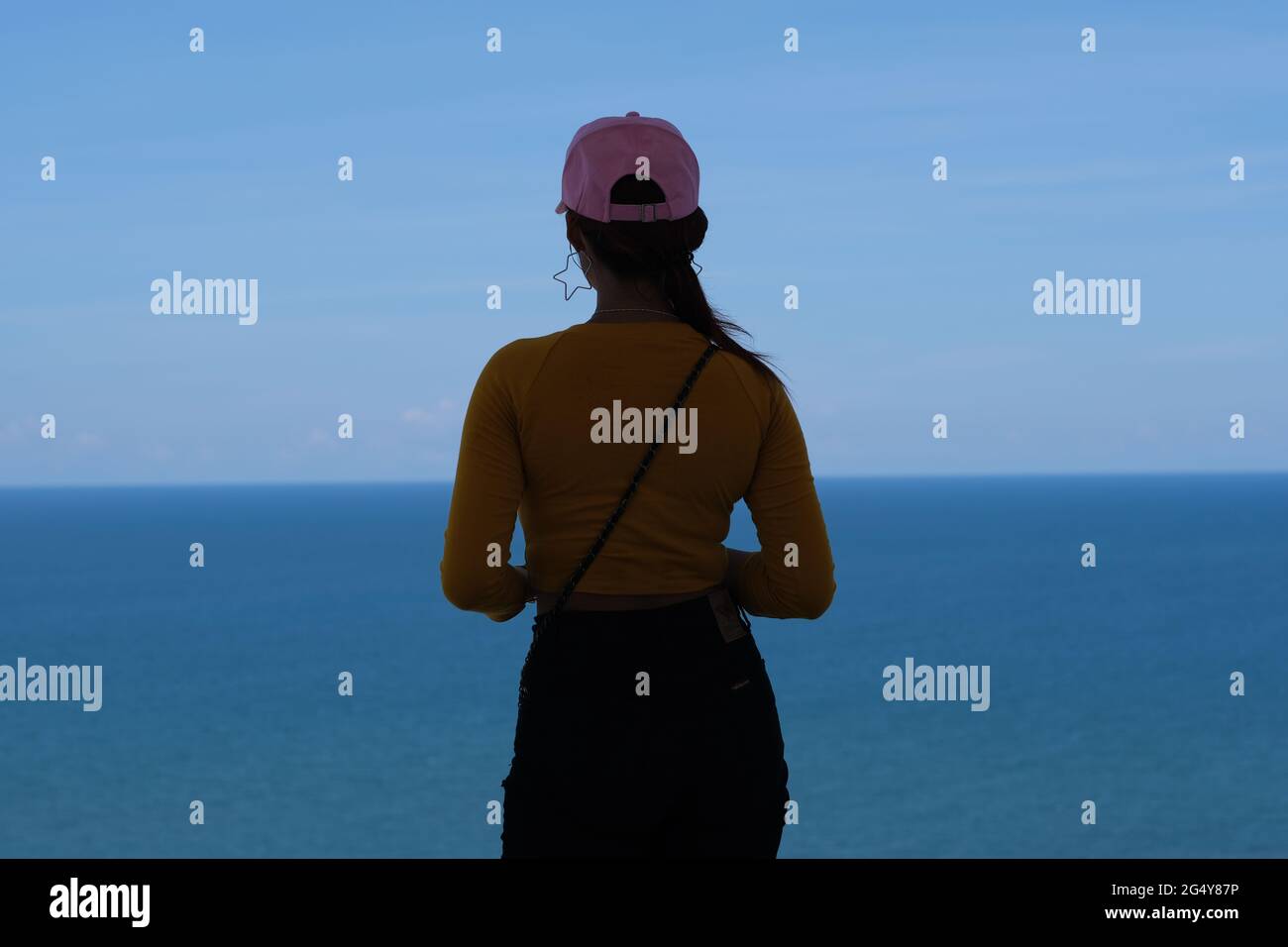 Une jeune femme se tient devant une mer sans fin Banque D'Images