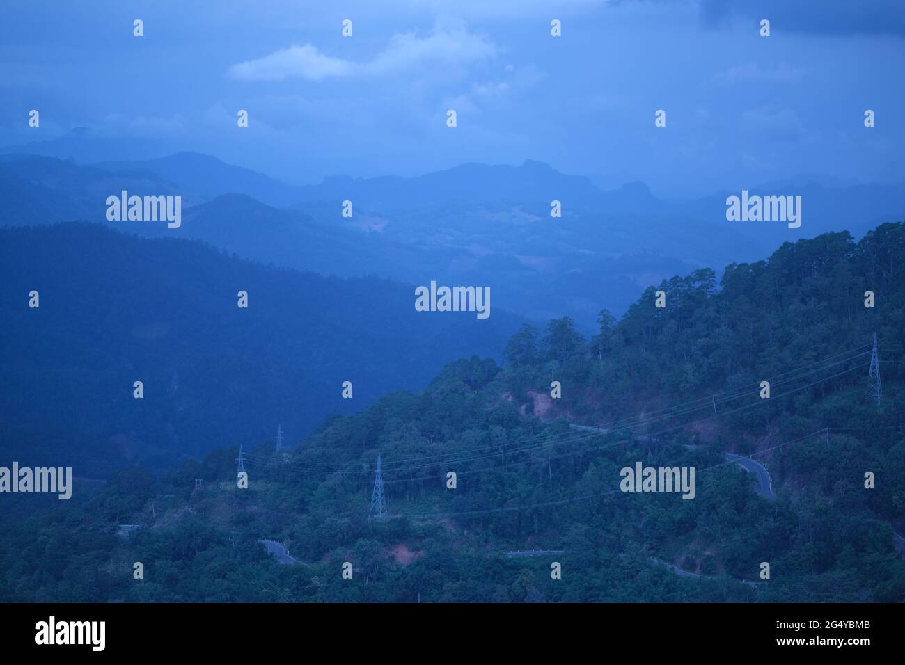 Lignes haute tension et route au-dessus de la région de montagne éloignée en fin de soirée Banque D'Images