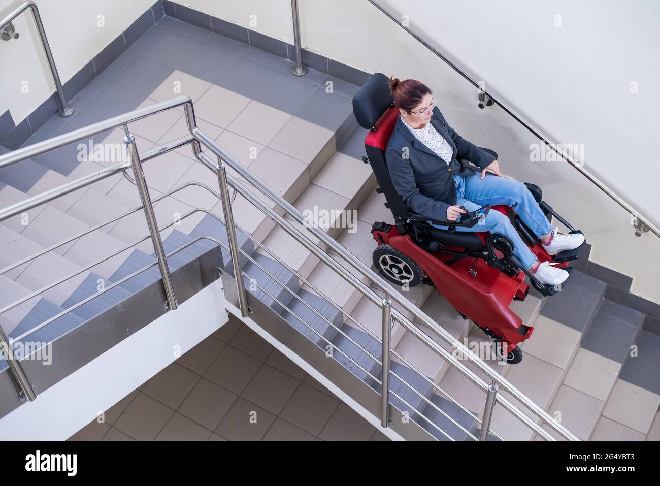 Femme caucasienne en fauteuil roulant avec chenille électrique descendant  les escaliers Photo Stock - Alamy