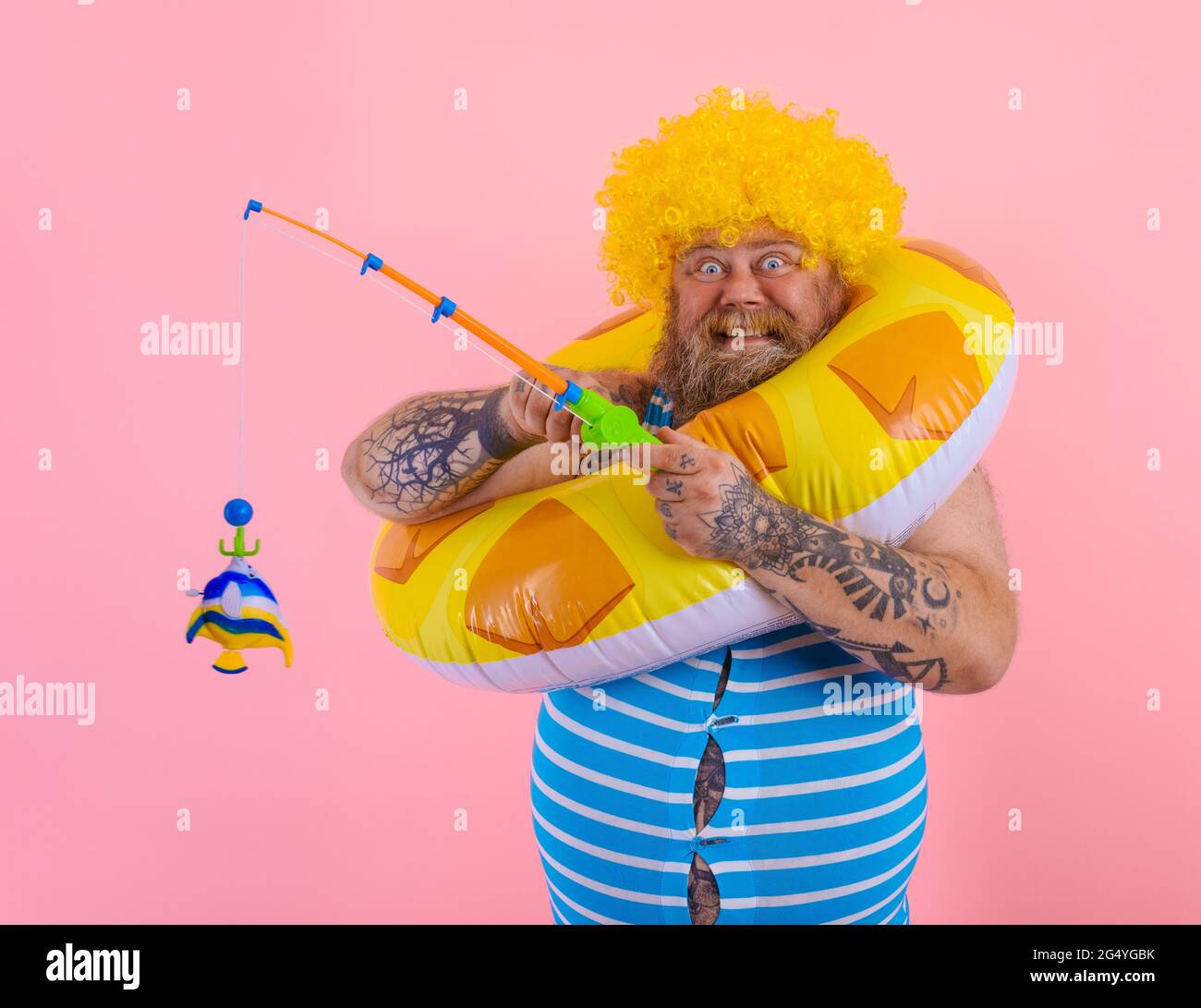 FAT Happy man avec perruque dans la tête joue avec la canne à pêche Photo  Stock - Alamy