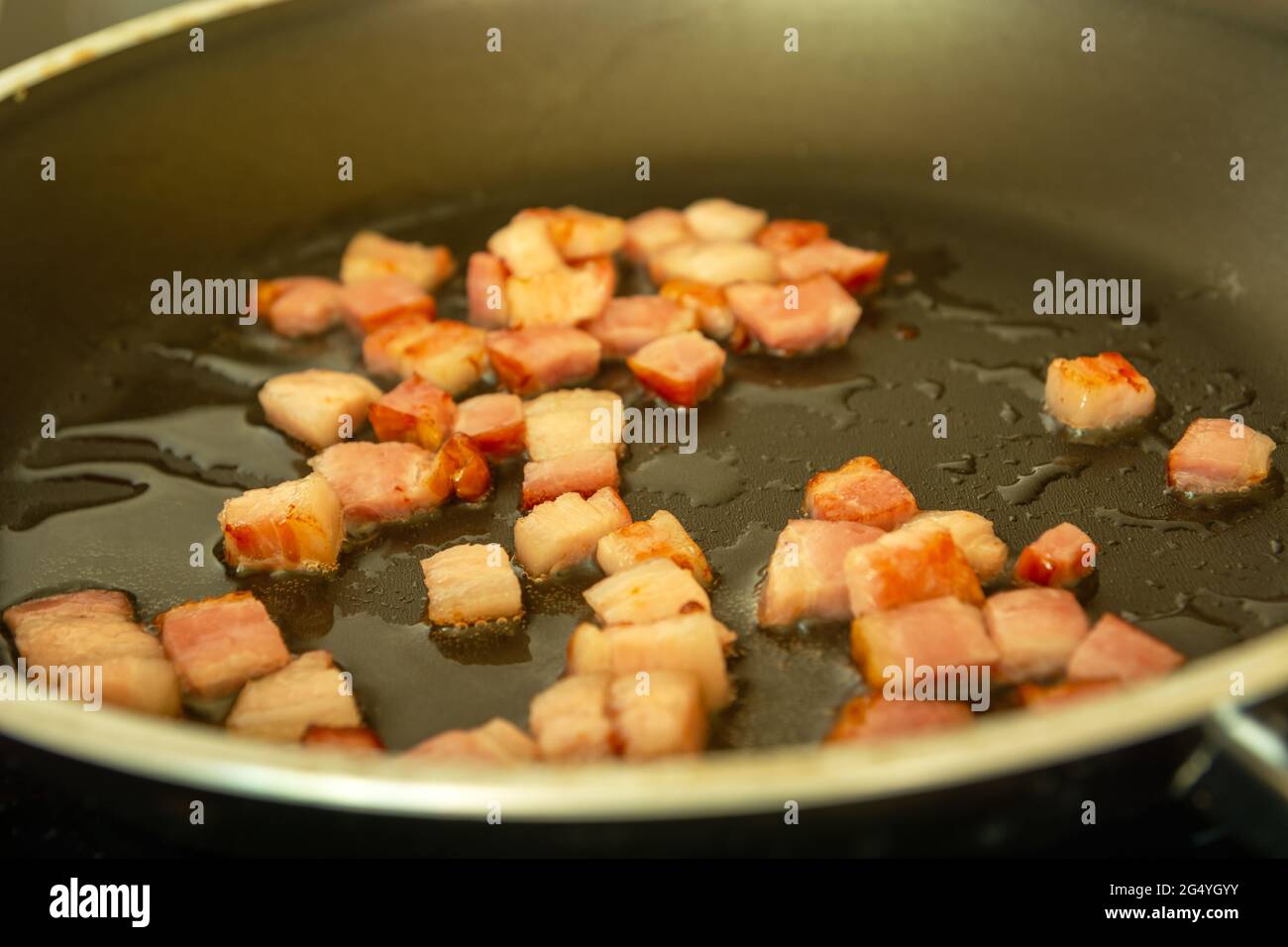 Bacon frais frits dans de l'huile dans une casserole Banque D'Images