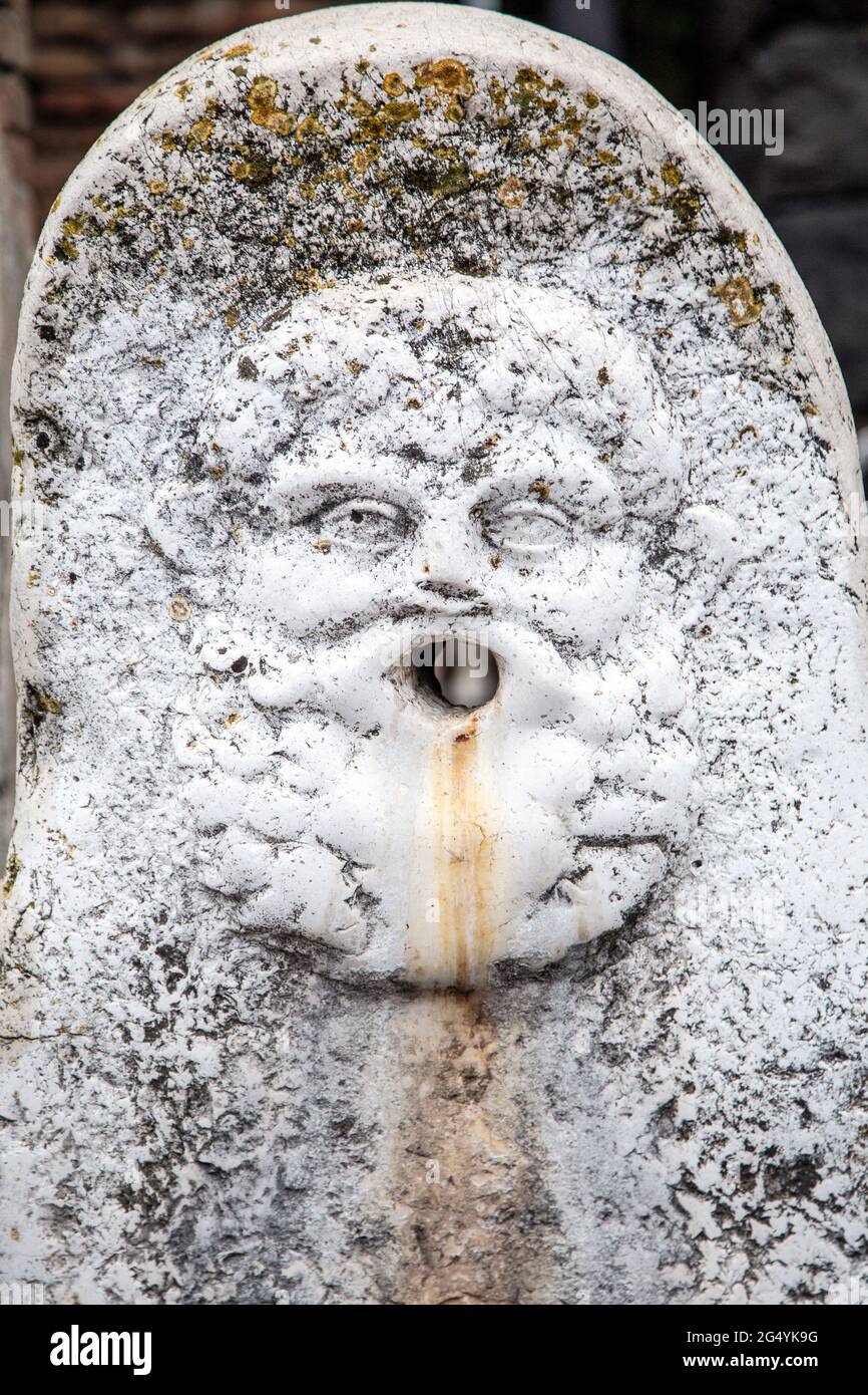 Détail de relief de visage sculpté sur une berge à cheval et une fontaine à boire au site archéologique de la ville antique d'Herculanum, Campanie, Italie Banque D'Images