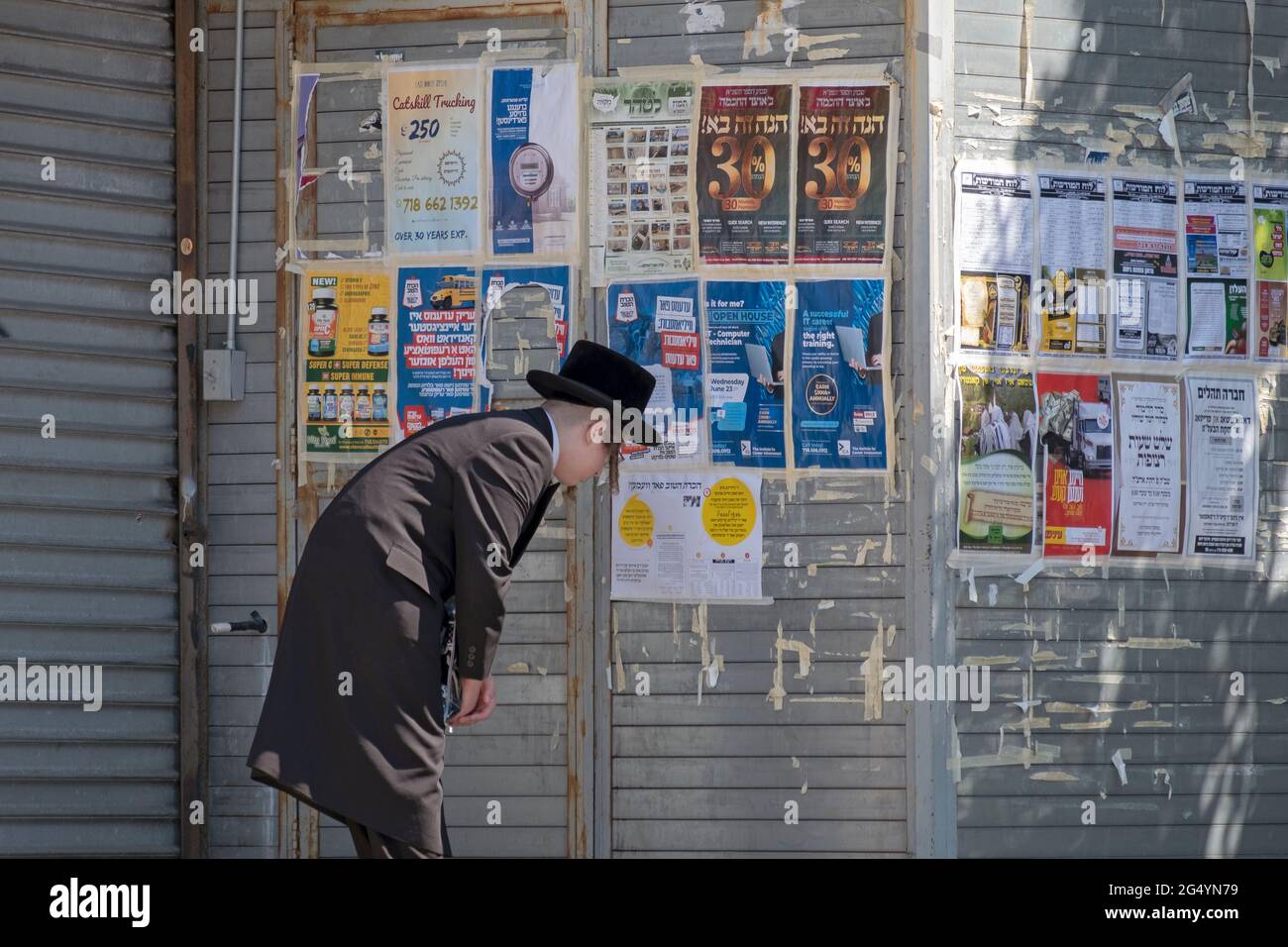 Un jeune juif orthodoxe regarde les affiches publicitaires qui sont