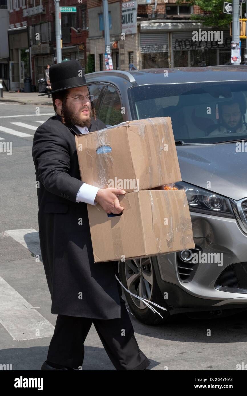 Un juif orthodoxe prend des paquets des articles d'été de son frère pour être utilisé dans le camp auquel il va assister. À Williamsburg, Brooklyn, New York ci Banque D'Images