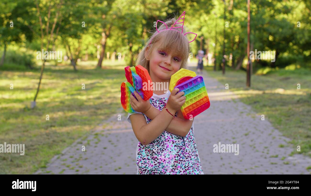 Sourire enfant fille enfant tenant pressant anti-stress pop il touch écran  jouets simple jeu de bosses Photo Stock - Alamy