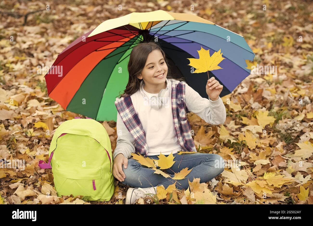 Se sentir au sec. Enfant d'automne sous un parapluie coloré. Laissez-vous  inspirer. Bonne enfance. Rentrée scolaire. Petite fille avec sac à dos,  détendez-vous dans le parc. Profitez de l'automne Photo Stock -