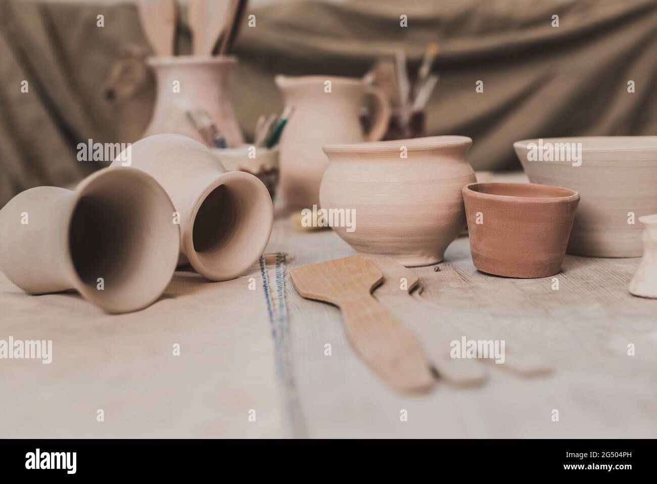 pots en argile faits à la main et matériel de poterie sur table en bois dans le studio d'art Banque D'Images