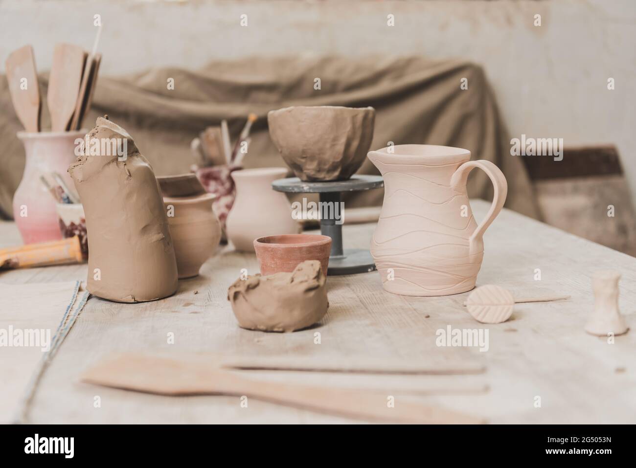 pots faits à la main, bol en argile sculpté et équipement de poterie sur table en bois Banque D'Images