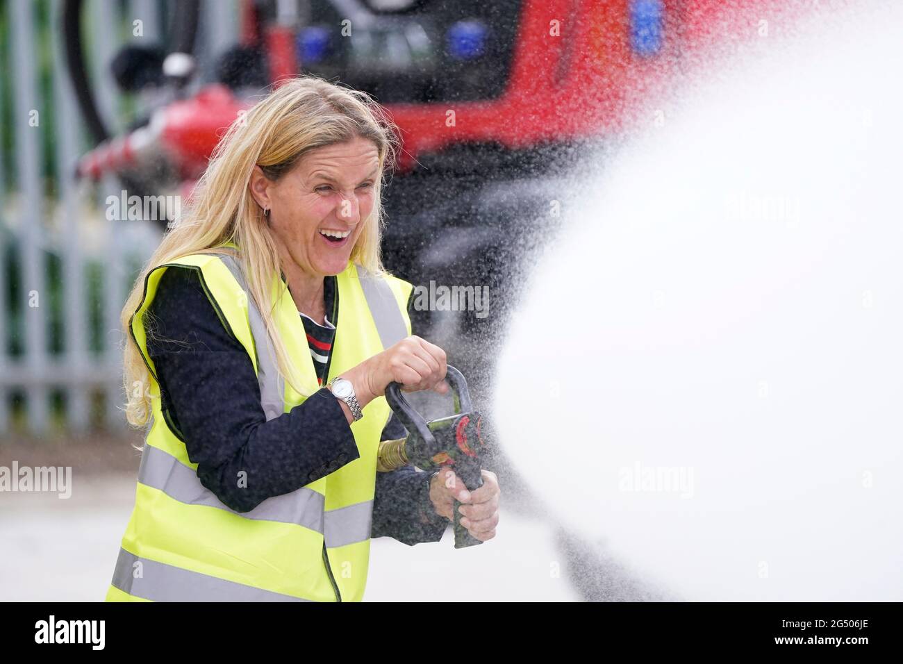 Kim Leadbeater, le candidat travailliste à l'élection partielle Batley et Spren, utilise un tuyau d'incendie lors d'une visite à Angloco, qui fabrique des moteurs d'incendie et des véhicules de secours utilisés dans tout le pays et dans le monde, alors qu'il est sur la piste de campagne avant l'élection partielle du 1er juillet. Date de la photo: Jeudi 24 juin 2021. Banque D'Images