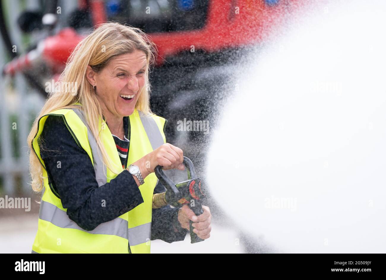 Kim Leadbeater, le candidat travailliste à l'élection partielle Batley et Spren, utilise un tuyau d'incendie lors d'une visite à Angloco, qui fabrique des moteurs d'incendie et des véhicules de secours utilisés dans tout le pays et dans le monde, alors qu'il est sur la piste de campagne avant l'élection partielle du 1er juillet. Date de la photo: Jeudi 24 juin 2021. Banque D'Images